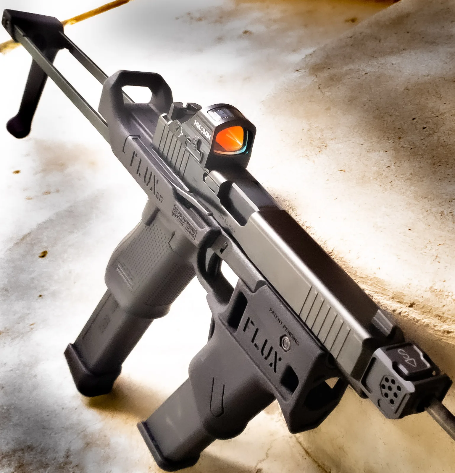 Glock pistol in a Flux Defense chassis with a gray Cerakote finish and red dot optic.