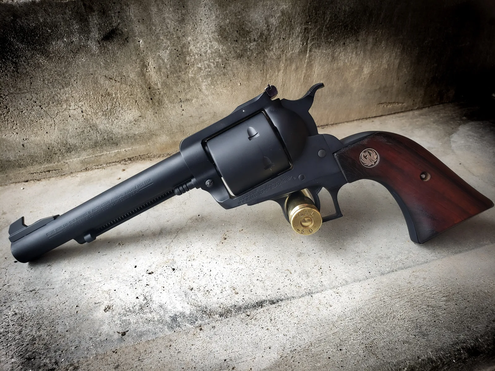 Long-barreled single-action revolver in a matte black Cerakote finish with wood grips.